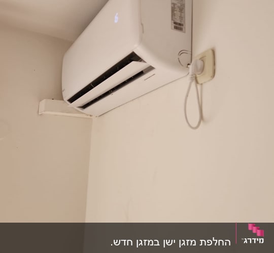 מזגן מותקן על קיר עם שקע חשמל
